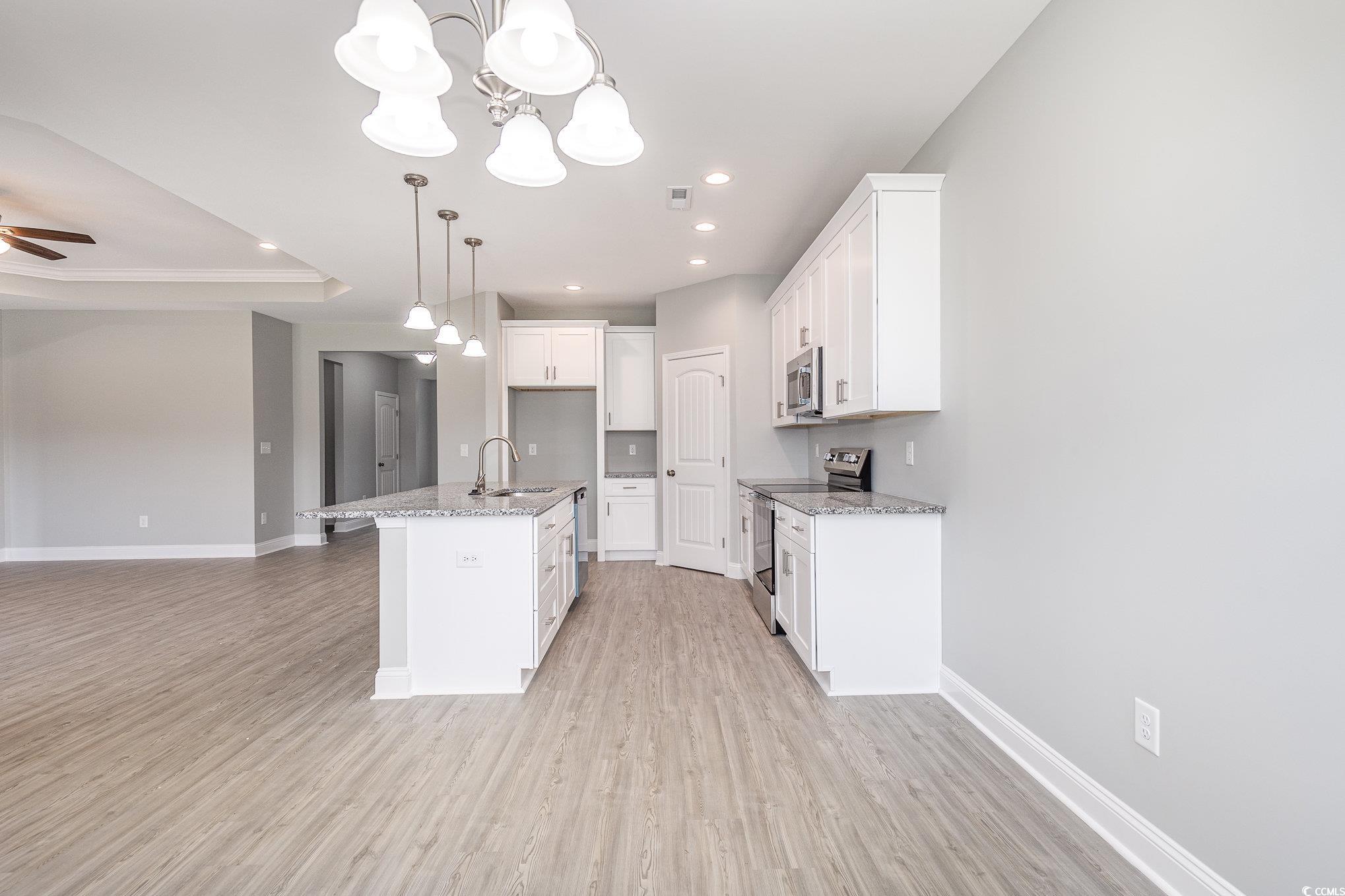363 Log Cabin Road Loris, SC 29569 - Photo 12 of 30 Kitchen featuring white cabinets, sink, a center i