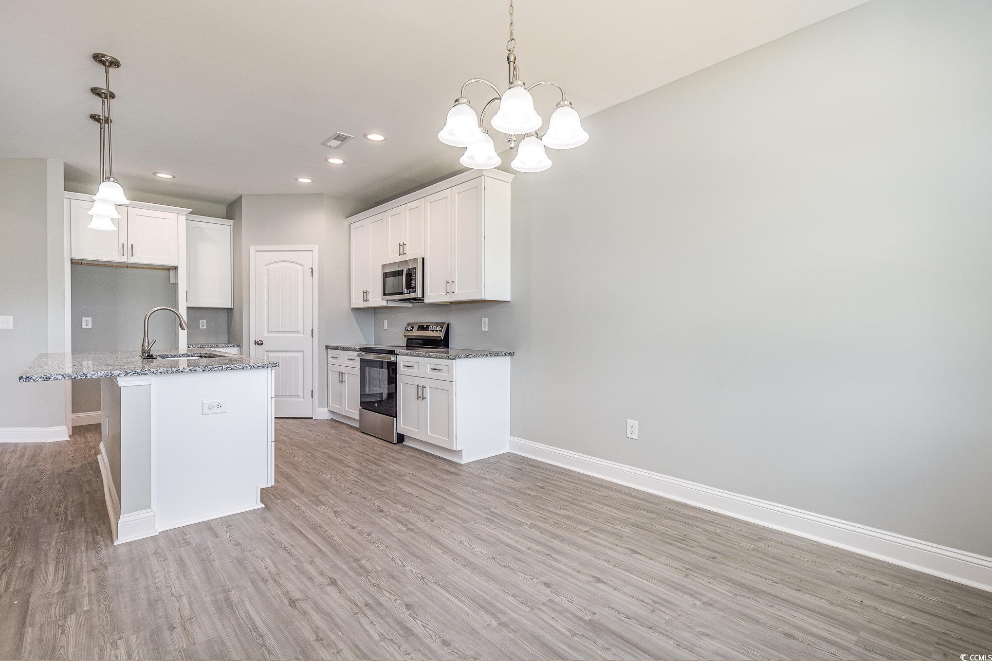 363 Log Cabin Road Loris, SC 29569 - Photo 13 of 30 Kitchen featuring white cabinets, an island with s
