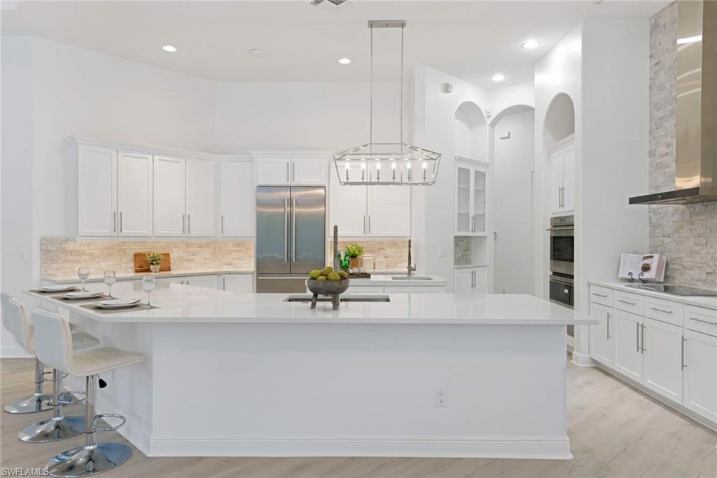 669 West Street Naples, FL 34108 - Photo 11 of 22 a large kitchen with kitchen island stainless steel appliances a sink and cabinets
