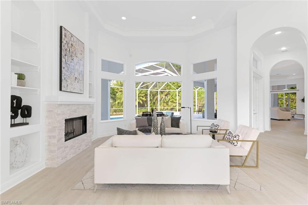 669 West Street Naples, FL 34108 - Photo 2 of 22 a living room with furniture a fireplace and a chandelier