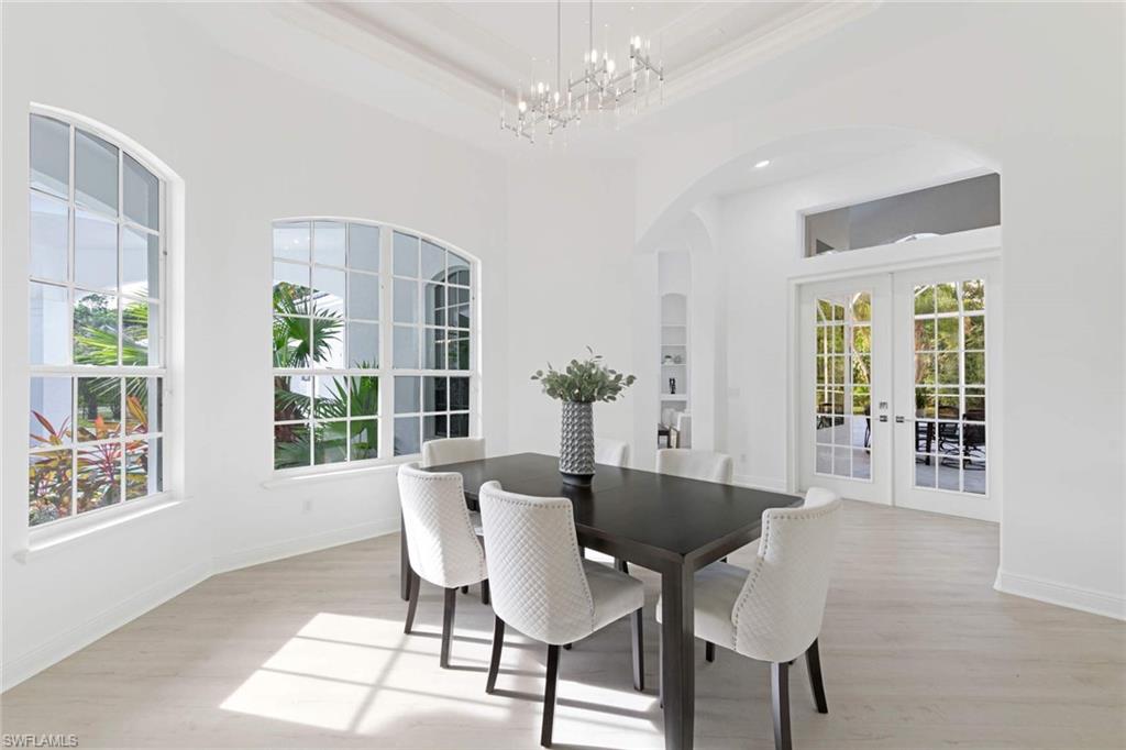 669 West Street Naples, FL 34108 - Photo 5 of 22 a dining room with furniture a chandelier and wooden floor