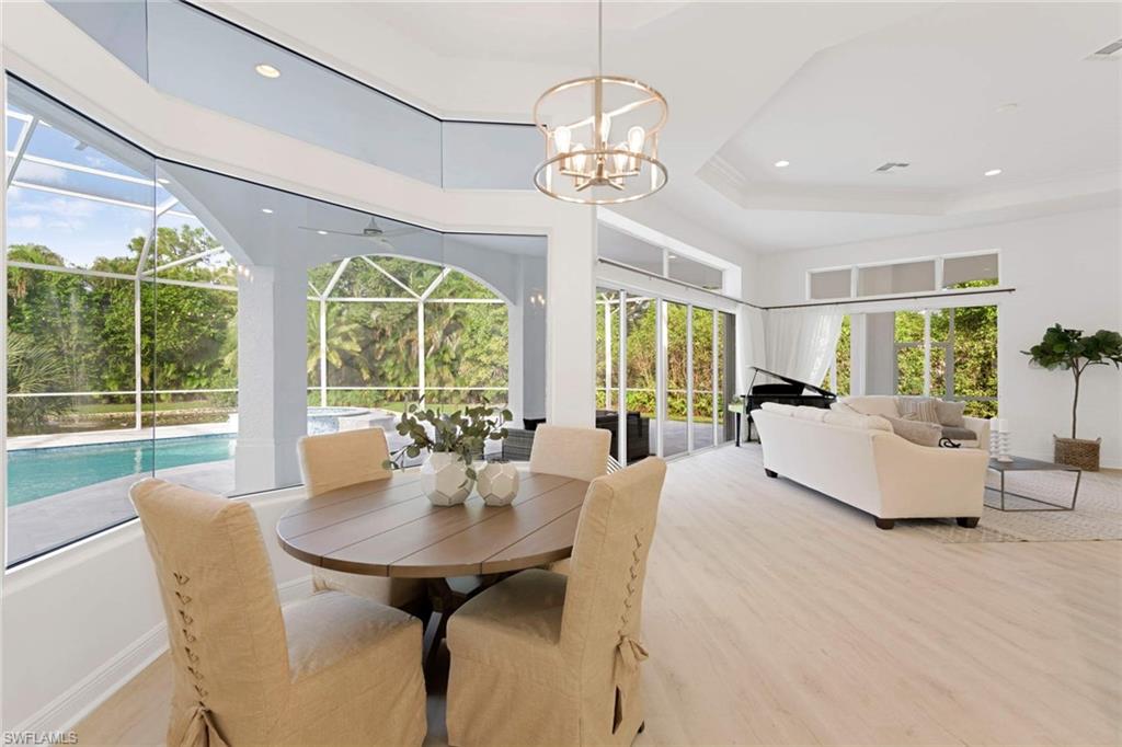 669 West Street Naples, FL 34108 - Photo 7 of 22 a view of a dining room with furniture wooden floor and chandelier