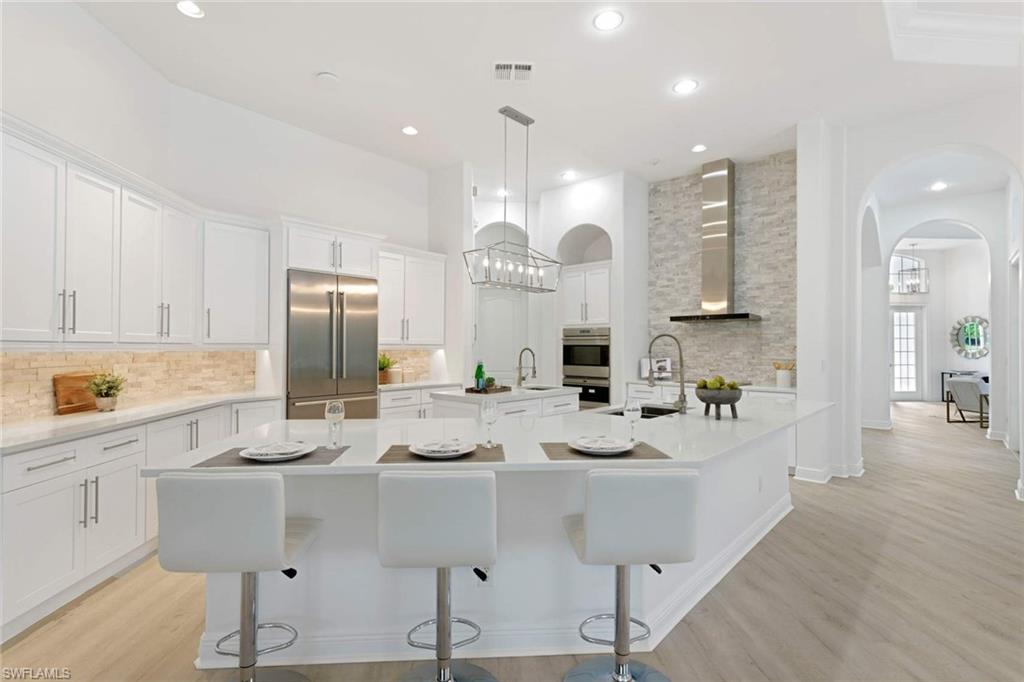 669 West Street Naples, FL 34108 - Photo 10 of 22 a kitchen with kitchen island granite countertop a sink cabinets and refrigerator