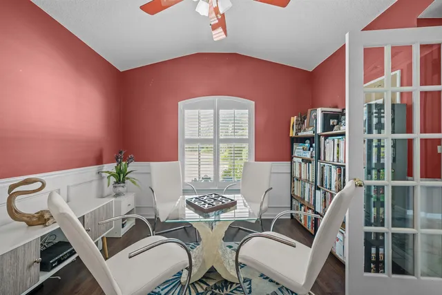 a dining room with furniture and a floor to ceiling window