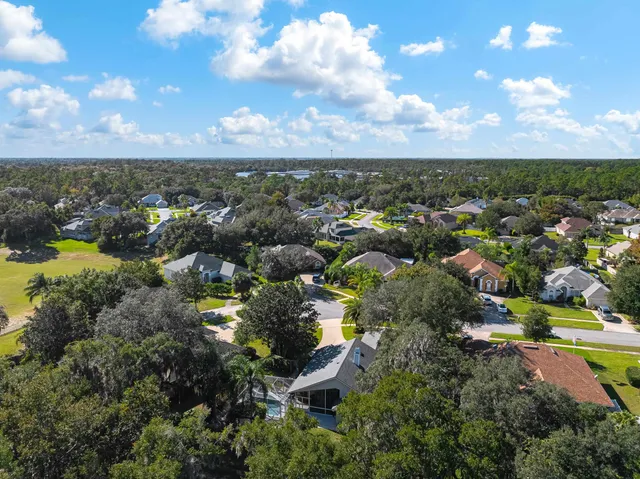 an aerial view of residential houses with outdoor space and ocean view