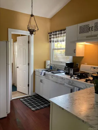 a kitchen with a refrigerator a stove a sink and a window