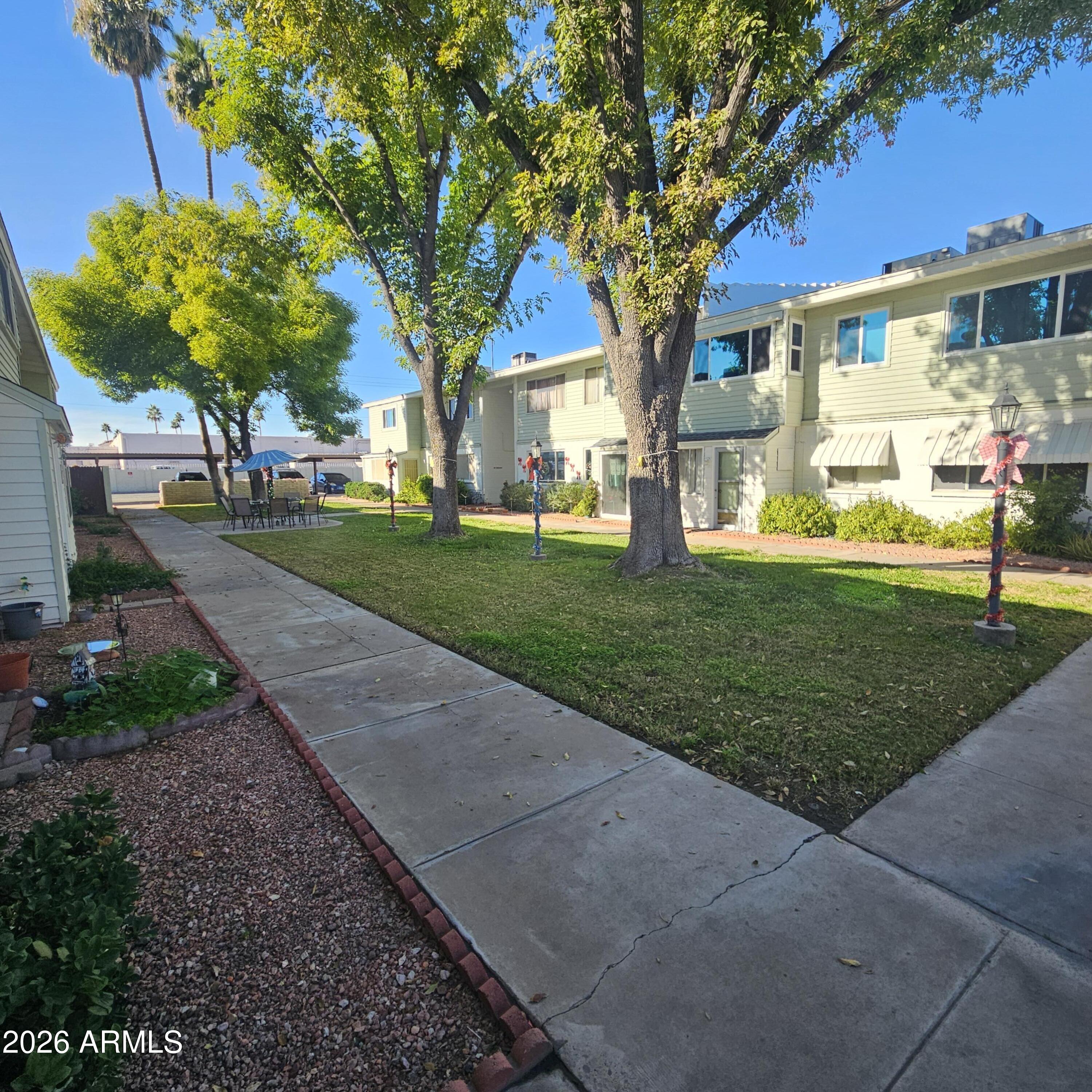 2575 West Berridge Lane, Unit D209 Phoenix, AZ 85017 - Photo 16 of 17 a front view of a house with a yard and trees