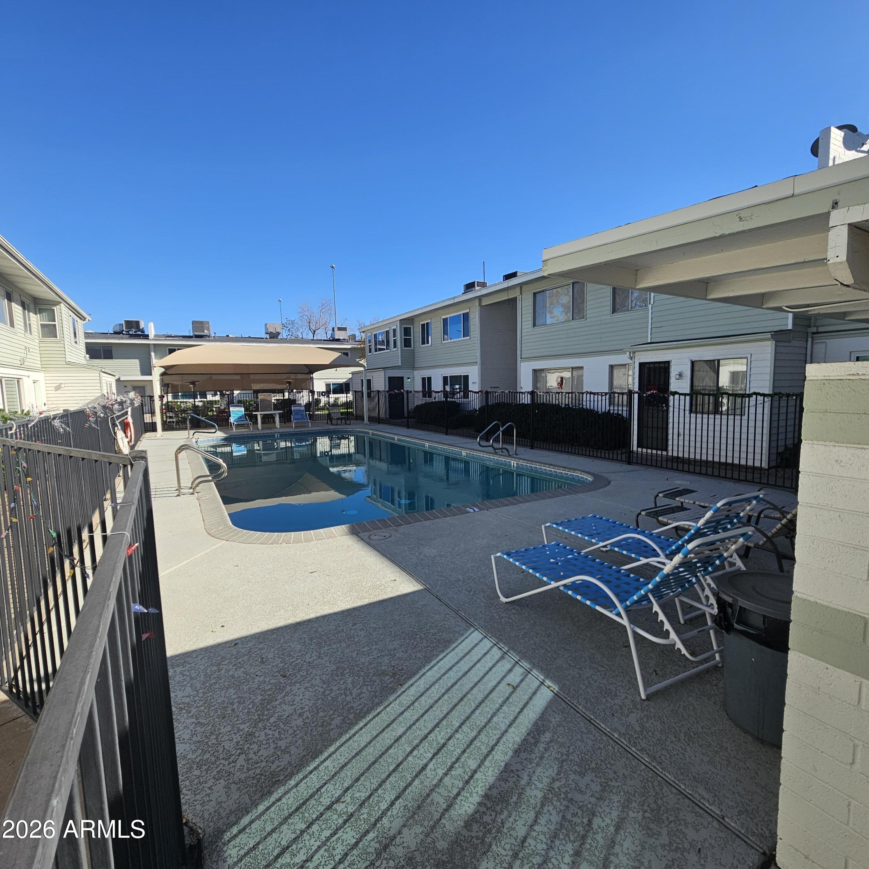 2575 West Berridge Lane, Unit D209 Phoenix, AZ 85017 - Photo 17 of 17 a view of a patio with table and chairs with wooden floor and fence