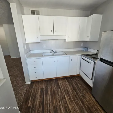 a kitchen with granite countertop white cabinets and white appliances