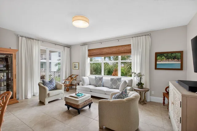 a living room with furniture kitchen view and a large window