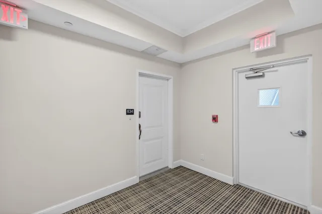 a view of a hallway to a livingroom with furniture