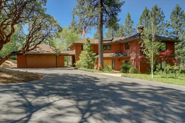 a front view of a house with a yard and tree s