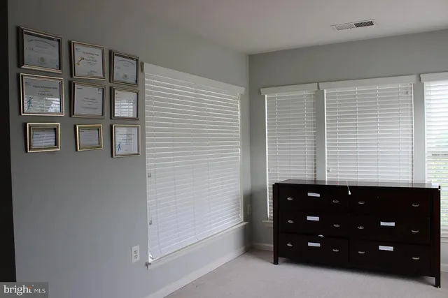 a bedroom with a bed and a flat tv screen on the dresser