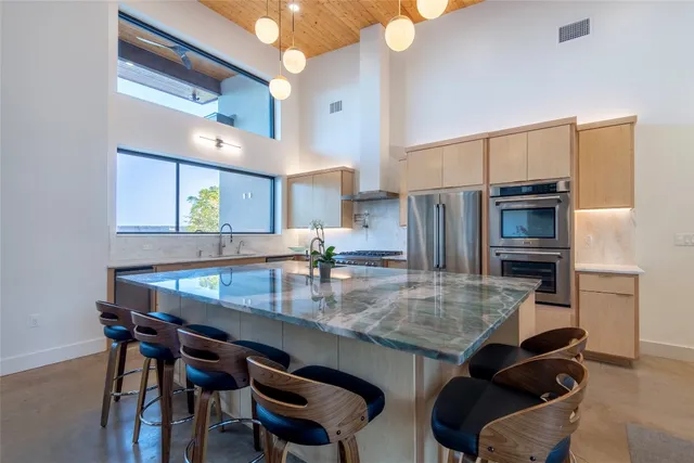 a kitchen with granite countertop a table chairs stove microwave and refrigerator