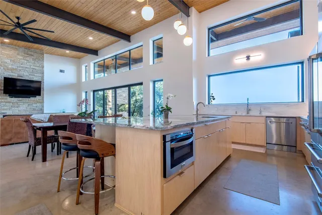 a large white kitchen with cabinets a sink and a stove
