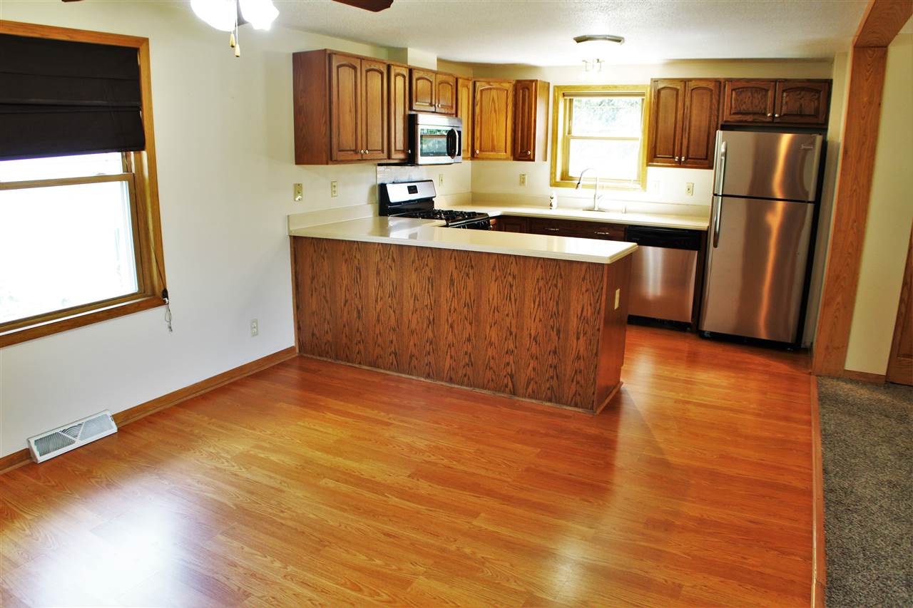 308 Pembroke Road Southwest Poplar Grove, IL 61065 - Photo 7 of 25 a kitchen with stainless steel appliances granite countertop a sink a stove a refrigerator and wooden floors