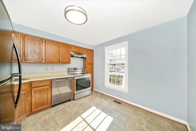 a kitchen with a sink a refrigerator and window