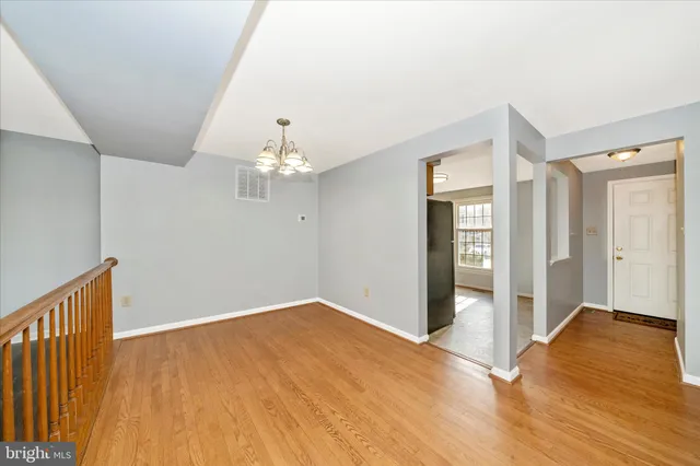 a view of an entryway wooden floor and chandelier