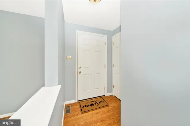 a kitchen with stainless steel appliances granite countertop a stove a sink and a white cabinets with wooden floor