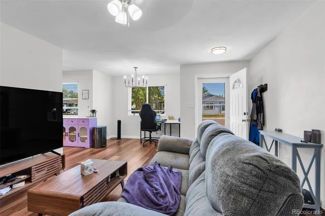 a living room with furniture a flat screen tv and large window