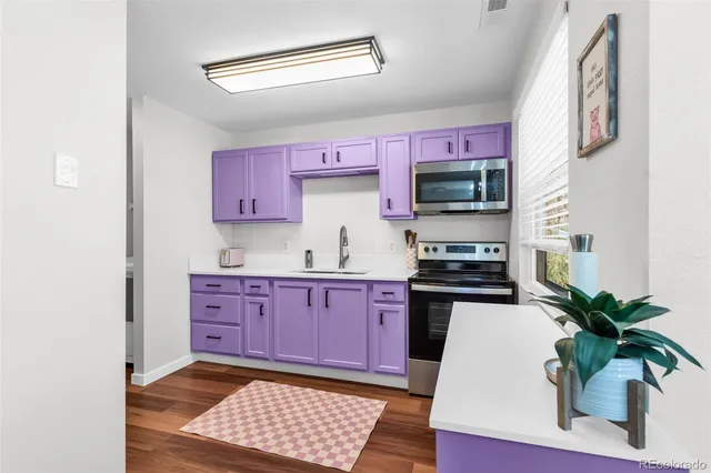 a kitchen with granite countertop a stove a sink and a microwave