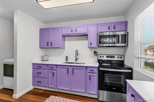 a kitchen with granite countertop a stove top oven microwave and cabinets