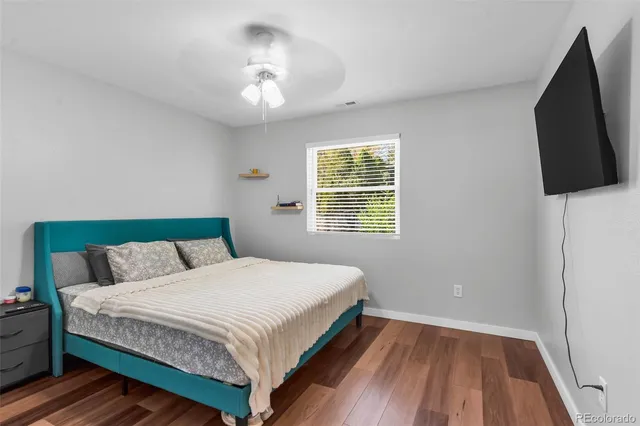 a bedroom with a bed a flat screen tv and window