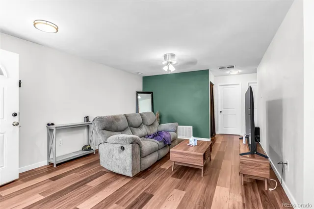 a living room with furniture and a wooden floor