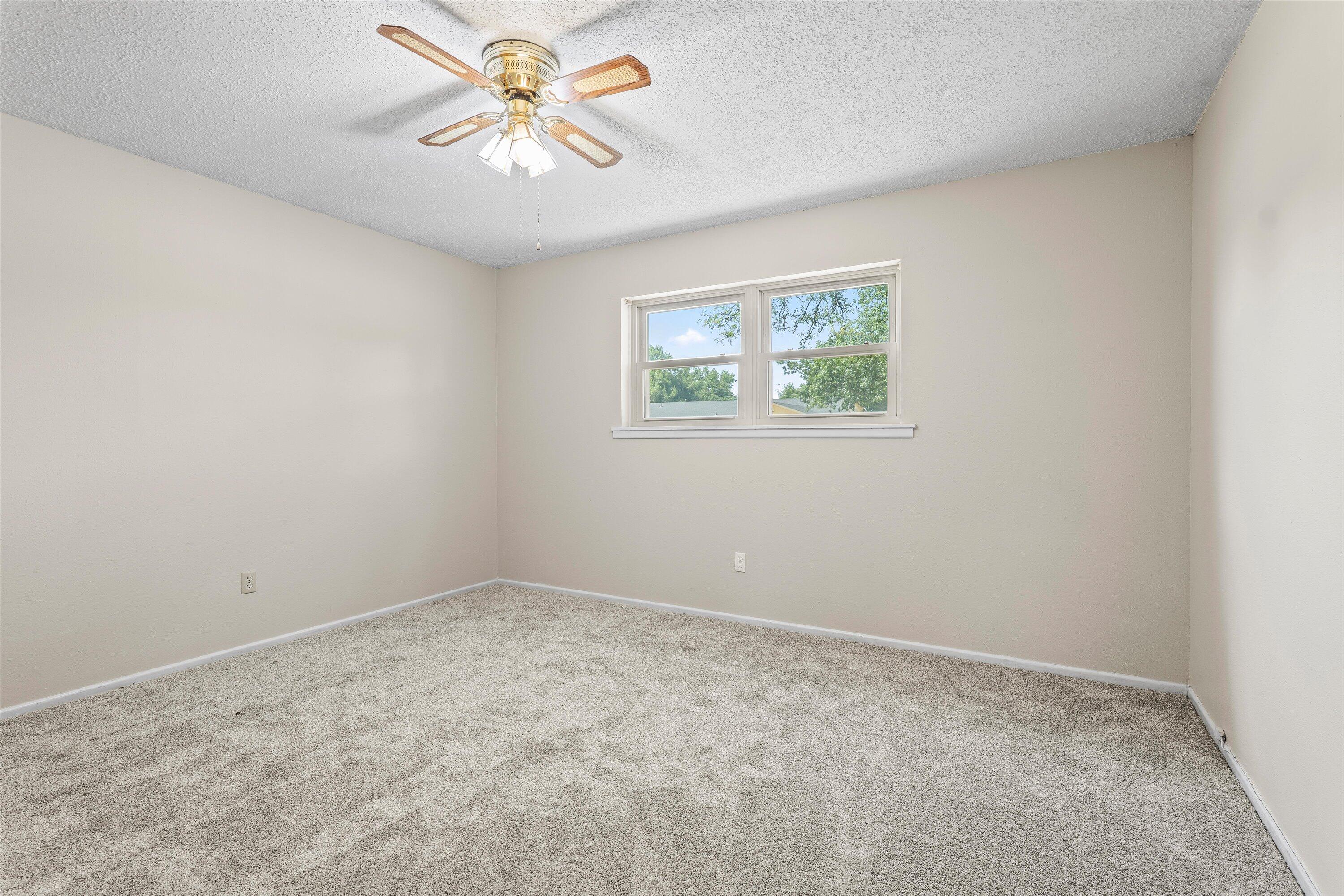 4520 54th Street Lubbock, TX 79414 - Photo 19 of 32 an empty room with windows and fan