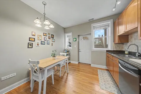 a view of a dining room with furniture a chandelier and wooden floor