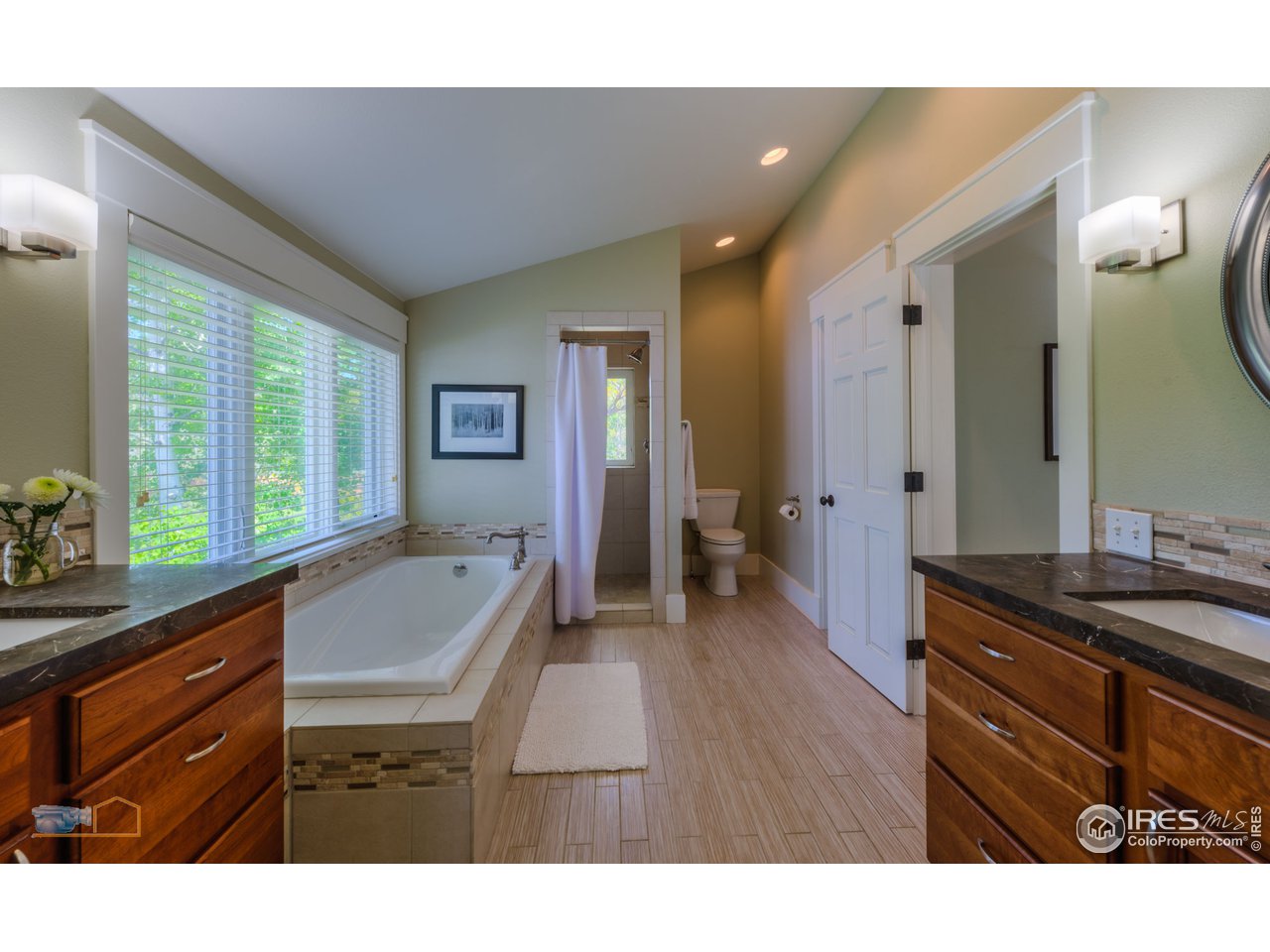 1799 Oak Avenue Boulder, CO 80304 - Photo 16 of 38 a spacious bathroom with a granite countertop sink a mirror and a bathtub