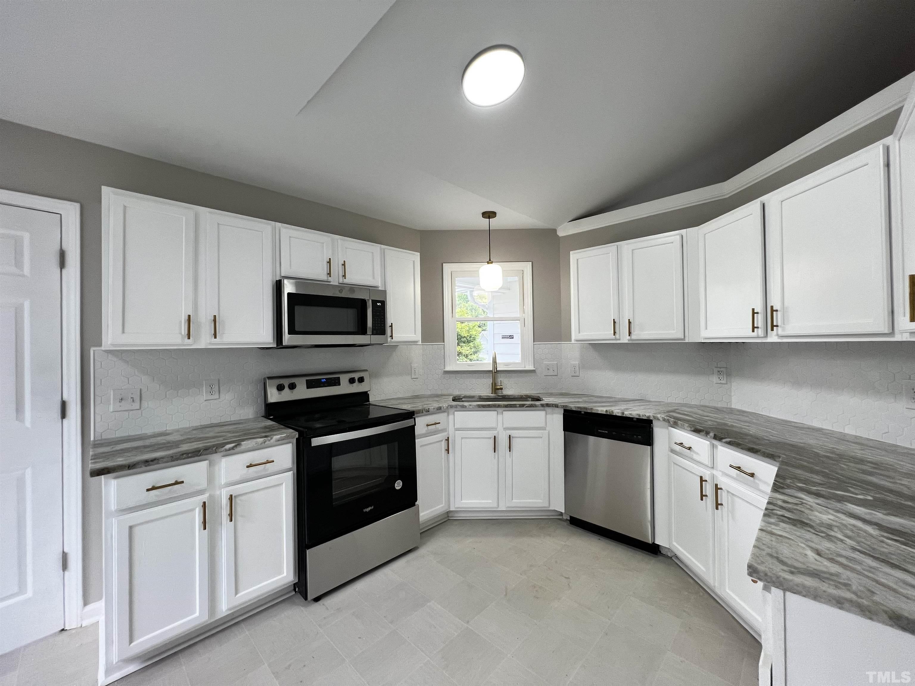 2109 Cardhu Way Raleigh, NC 27603 - Photo 11 of 40 a kitchen with granite countertop white cabinets sink and stainless steel appliances