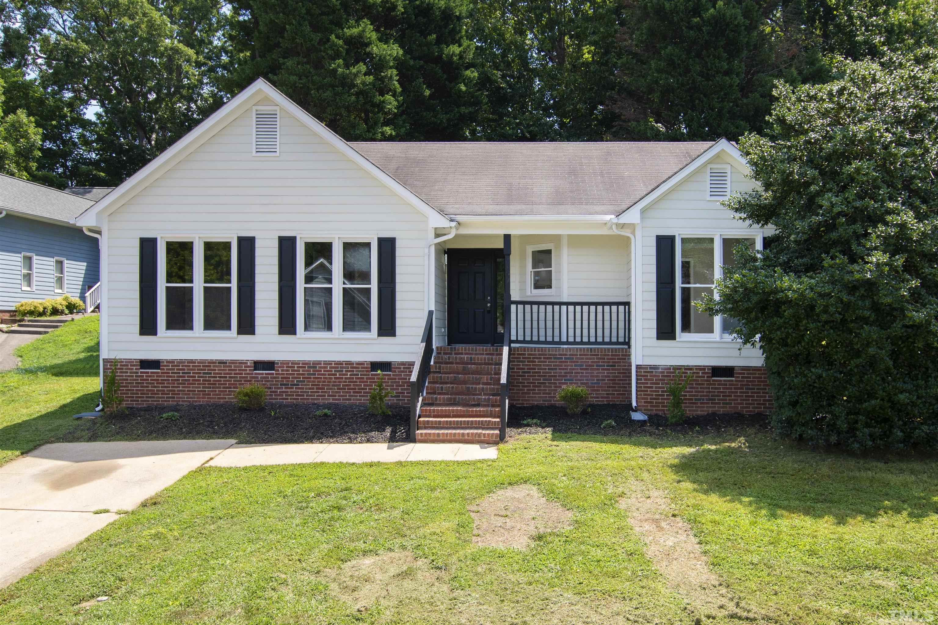 2109 Cardhu Way Raleigh, NC 27603 - Photo 24 of 40 a front view of a house with a garden and trees