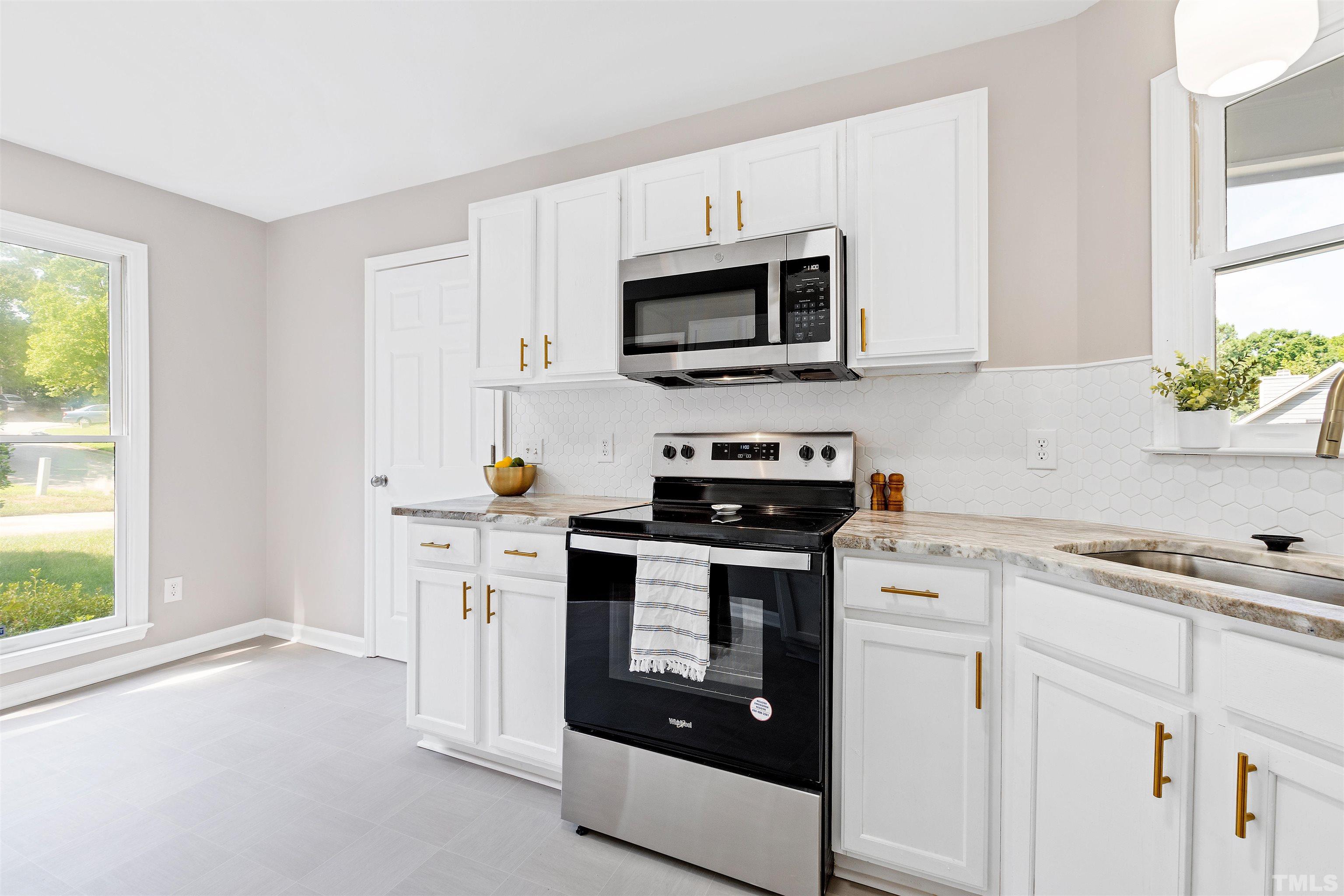2109 Cardhu Way Raleigh, NC 27603 - Photo 28 of 40 a kitchen with stainless steel appliances white cabinets and a stove top oven
