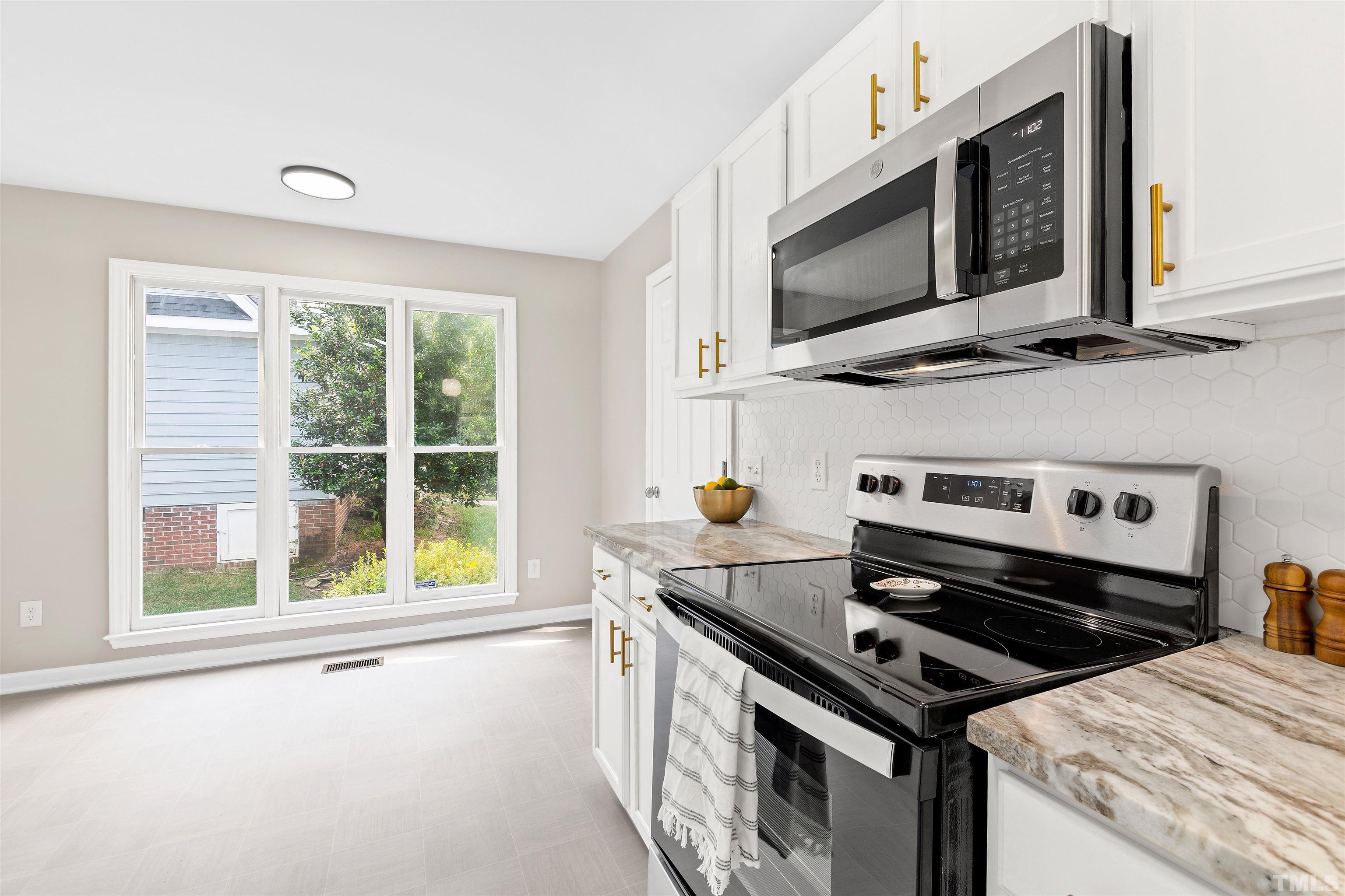 2109 Cardhu Way Raleigh, NC 27603 - Photo 29 of 40 a kitchen with a stove microwave and sink