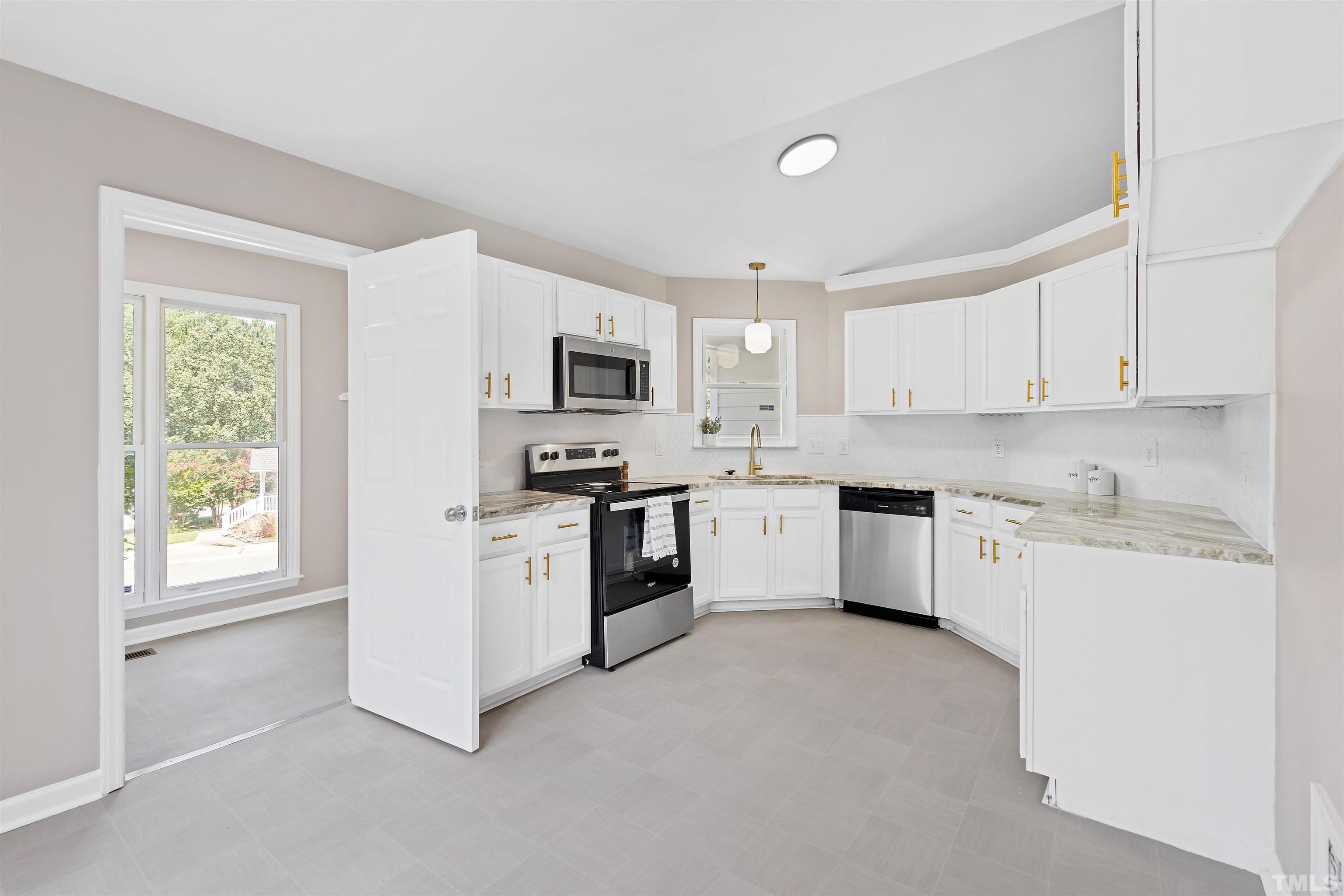 2109 Cardhu Way Raleigh, NC 27603 - Photo 31 of 40 a kitchen with white cabinets and white appliances