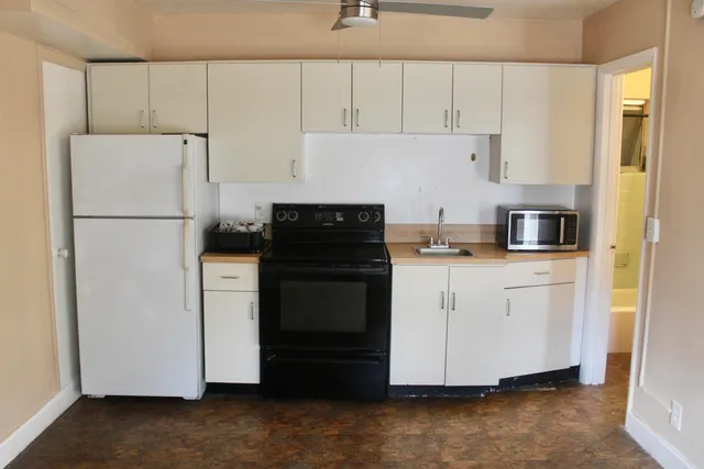 a kitchen with a refrigerator sink stove and cabinets