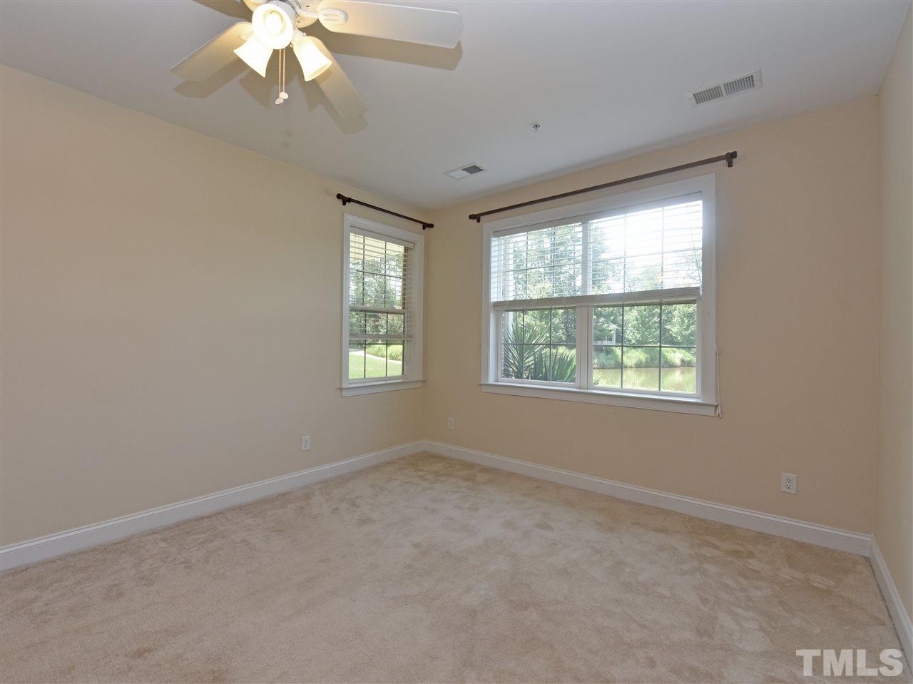 10411 Rosegate Court, Unit 5 Raleigh, NC 27617 - Photo 14 of 24 an empty room with a chandelier fan and windows