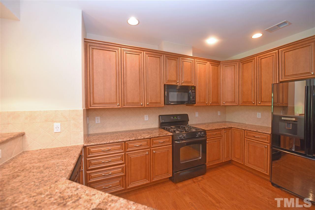 10411 Rosegate Court, Unit 5 Raleigh, NC 27617 - Photo 8 of 24 a kitchen with stainless steel appliances granite countertop a stove a sink and a refrigerator