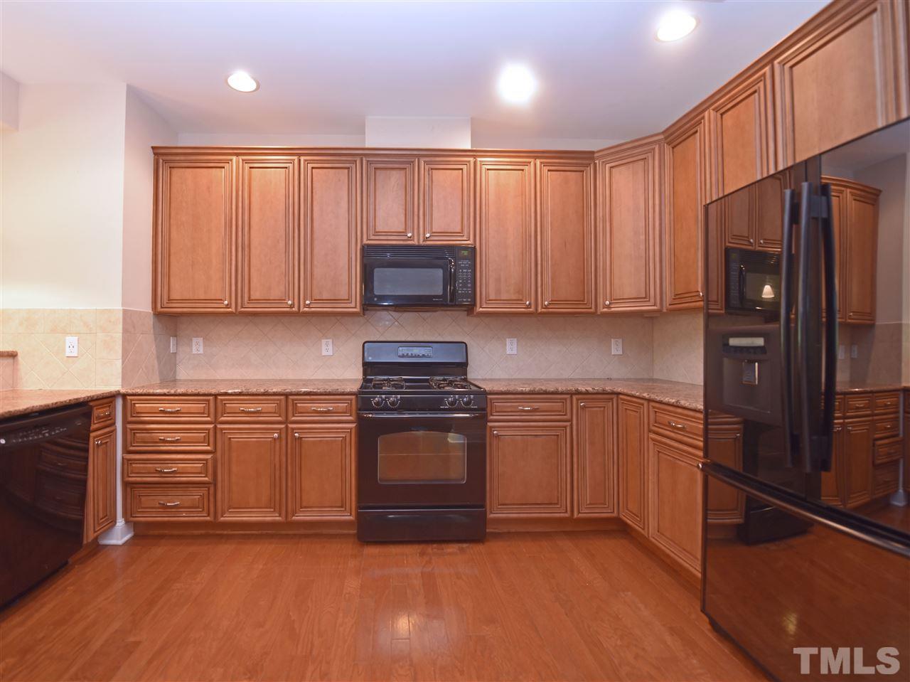 10411 Rosegate Court, Unit 5 Raleigh, NC 27617 - Photo 10 of 24 a kitchen with granite countertop wooden cabinets and stainless steel appliances