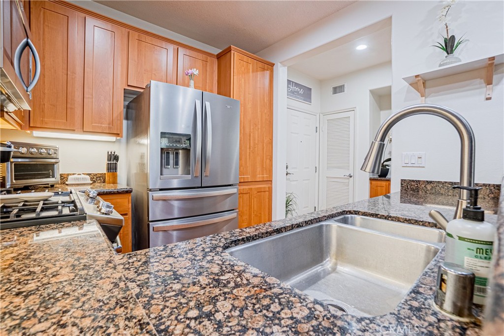 12668 Chapman Avenue, Unit 2108 Garden Grove, CA 92840 - Photo 12 of 40 a kitchen with stainless steel appliances granite countertop a sink a stove and a refrigerator