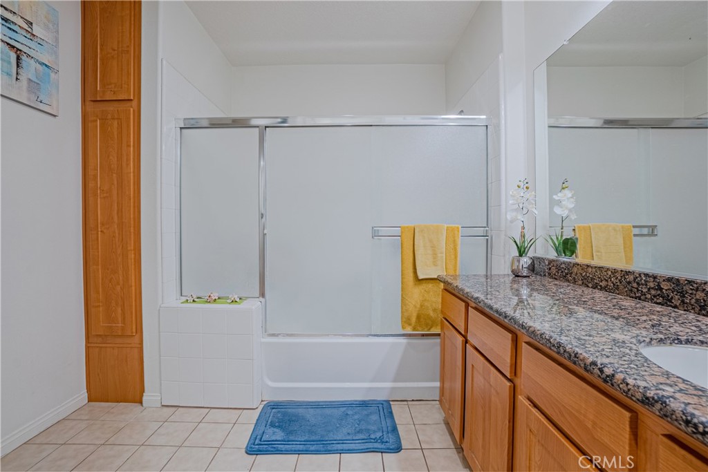12668 Chapman Avenue, Unit 2108 Garden Grove, CA 92840 - Photo 16 of 40 a bathroom with a granite countertop sink and a mirror