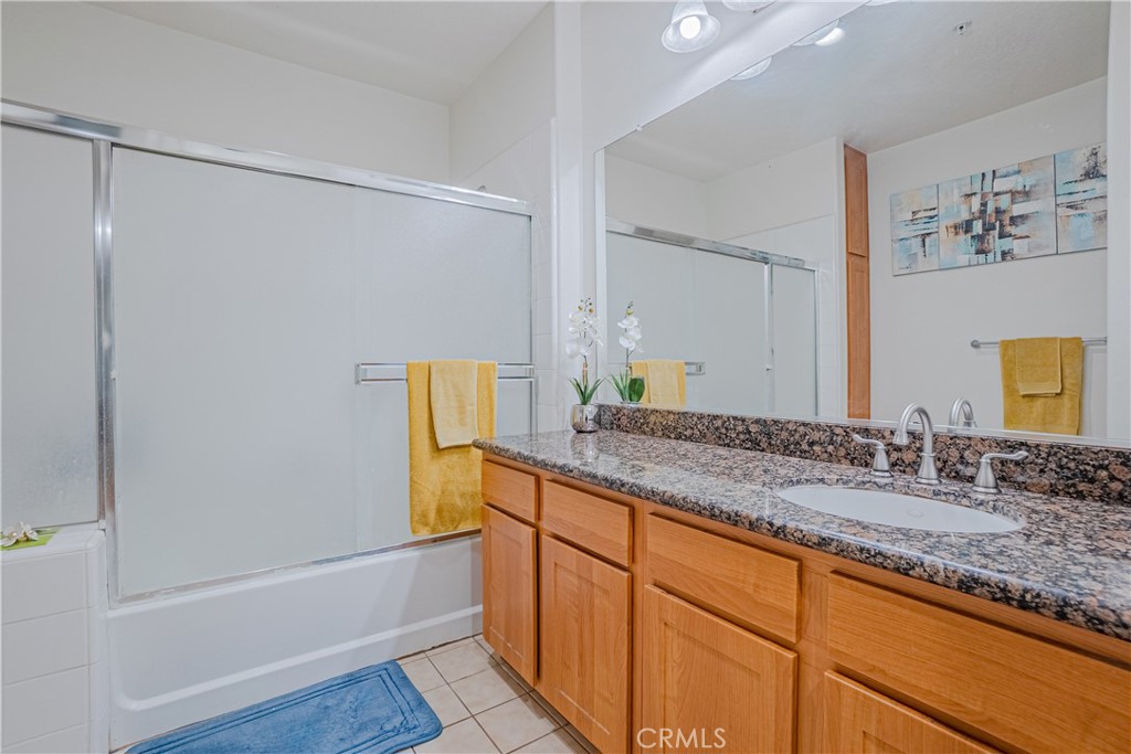12668 Chapman Avenue, Unit 2108 Garden Grove, CA 92840 - Photo 17 of 40 a bathroom with a granite countertop sink and a mirror