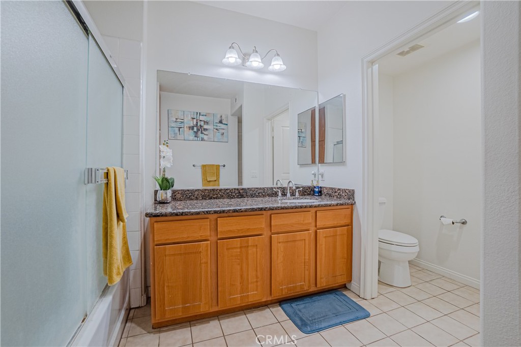 12668 Chapman Avenue, Unit 2108 Garden Grove, CA 92840 - Photo 18 of 40 a bathroom with a granite countertop sink and a mirror