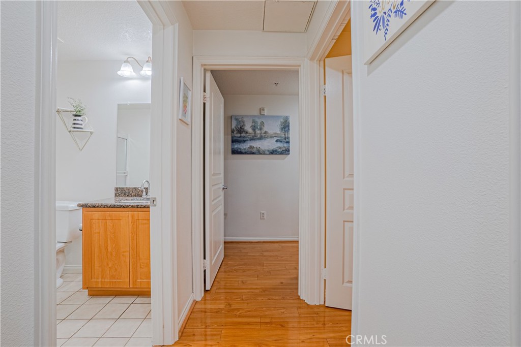 12668 Chapman Avenue, Unit 2108 Garden Grove, CA 92840 - Photo 22 of 40 a view of a hallway with wooden floor and a bathroom