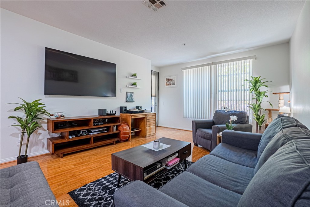 12668 Chapman Avenue, Unit 2108 Garden Grove, CA 92840 - Photo 3 of 40 a living room with furniture and a flat screen tv