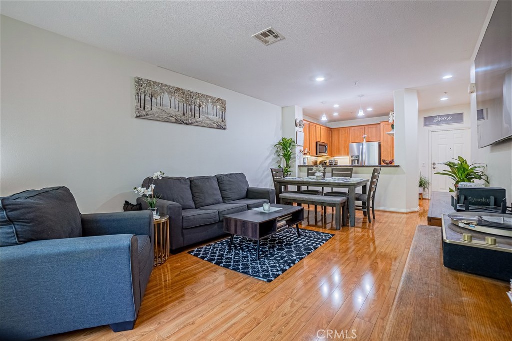 12668 Chapman Avenue, Unit 2108 Garden Grove, CA 92840 - Photo 4 of 40 a living room with furniture and a wooden floor
