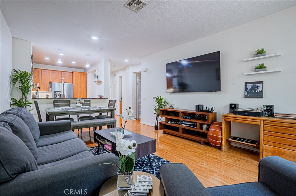 12668 Chapman Avenue, Unit 2108 Garden Grove, CA 92840 - Photo 5 of 40 a living room with furniture and a flat screen tv