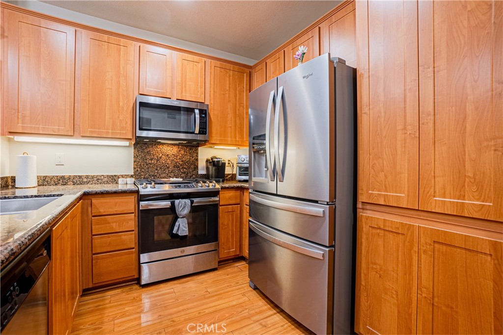 12668 Chapman Avenue, Unit 2108 Garden Grove, CA 92840 - Photo 10 of 40 a kitchen with stainless steel appliances granite countertop a refrigerator microwave and sink