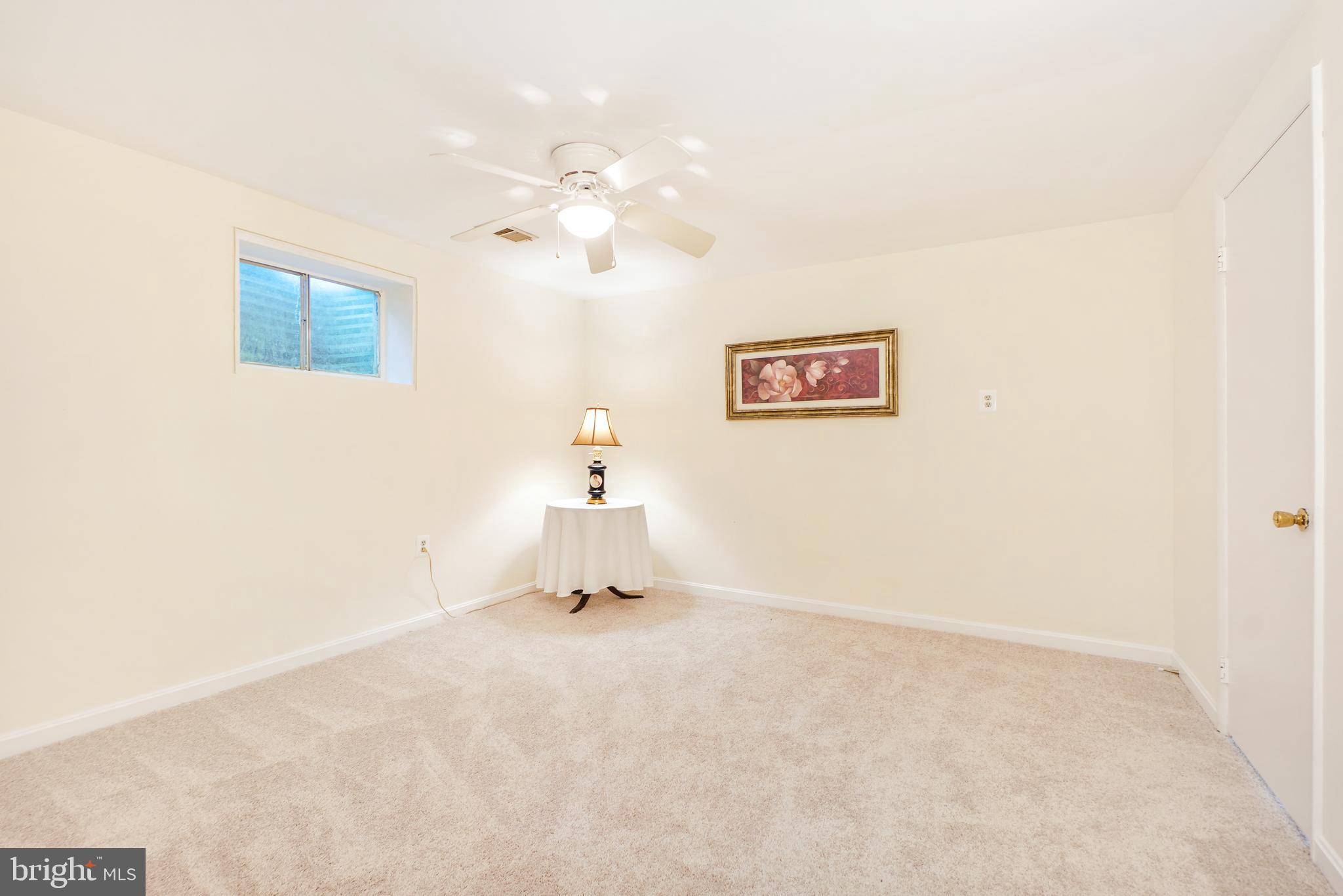 8900 Centerway Road Gaithersburg, MD 20879 - Photo 23 of 32 an empty room with a wall painting and a ceiling fan